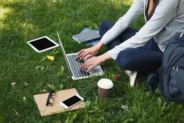 Young woman using laptop in park