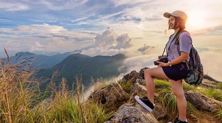 Girl tourist on mountains at sunset